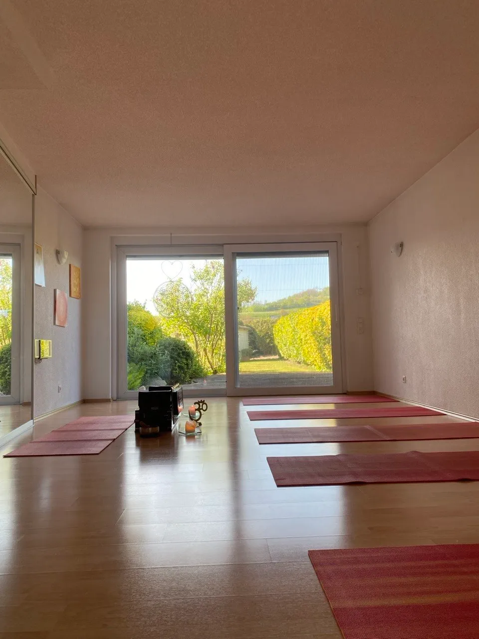 Yogaraum mit Matten und Blick in den Garten