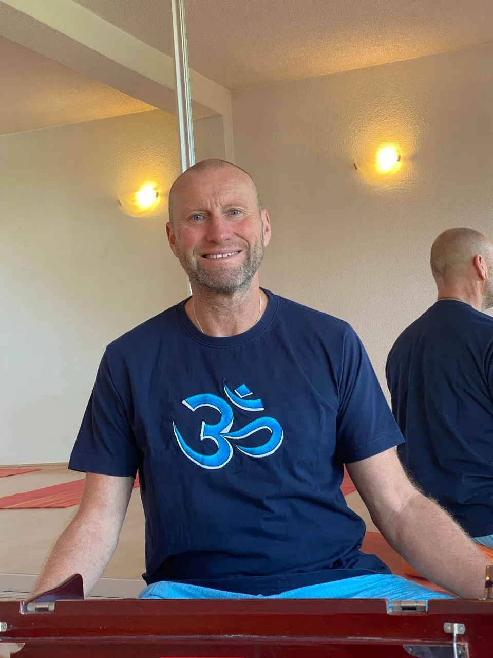 Christian Pfaff lächelnd im Yogaraum