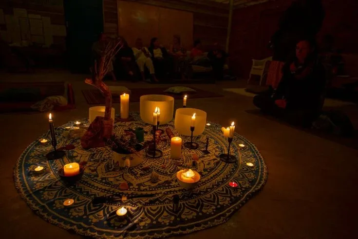 Klangschalen und Kerzen auf einer Mandala-Decke bei einem Seminar